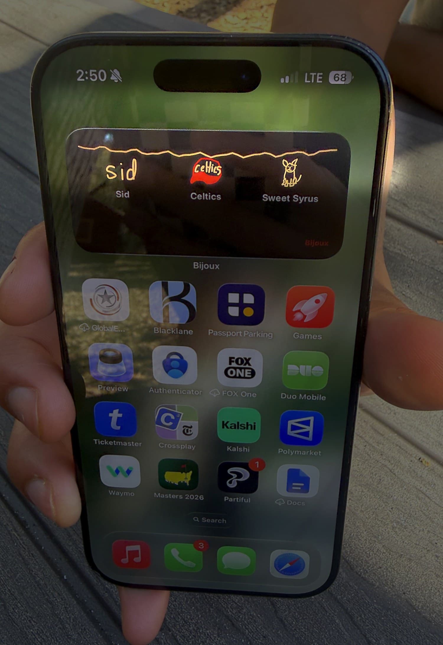 One phone: a bijou with their partner's name in gold script, hanging beside a Celtics crest and Sweet Syrus.